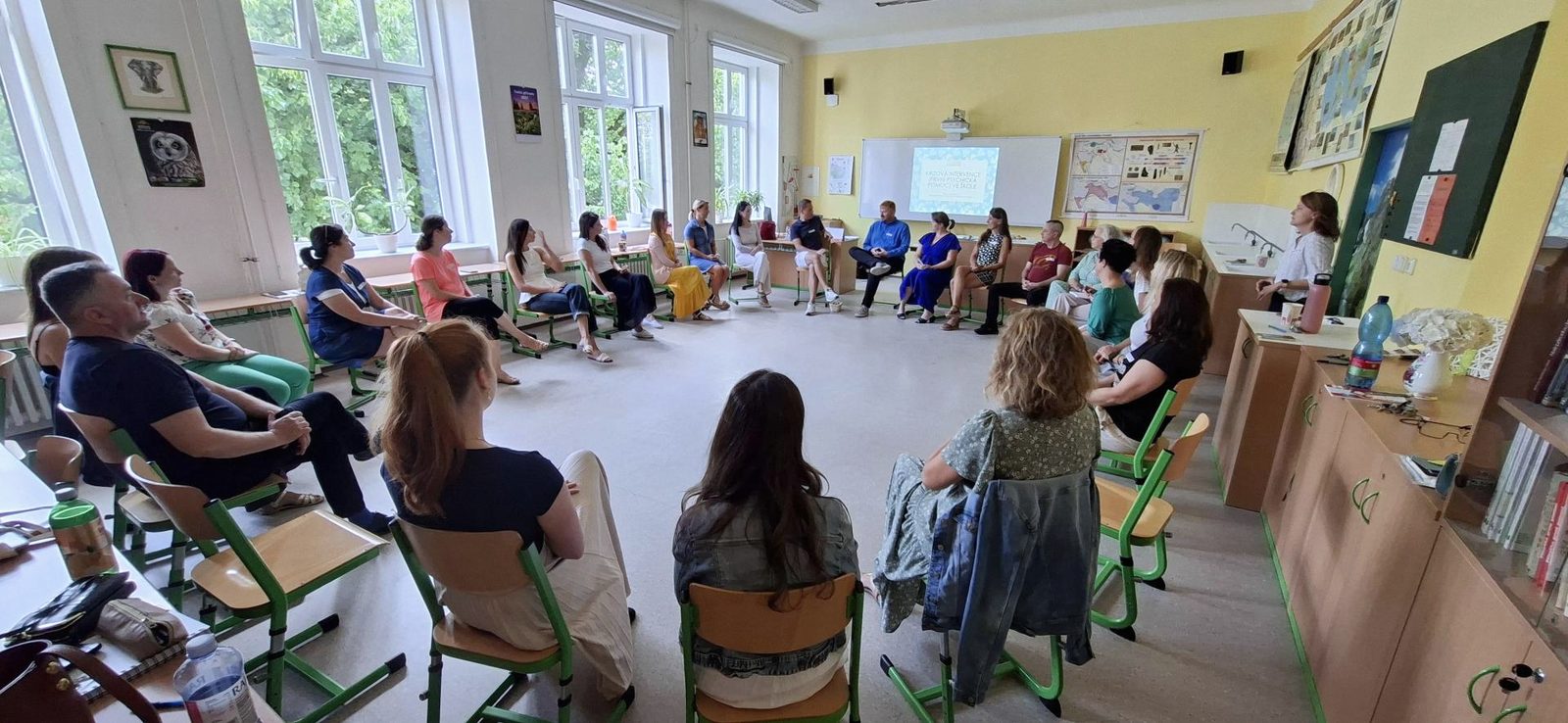 Sborovna v kruhu na semináři — lidé se smějí a povídají si